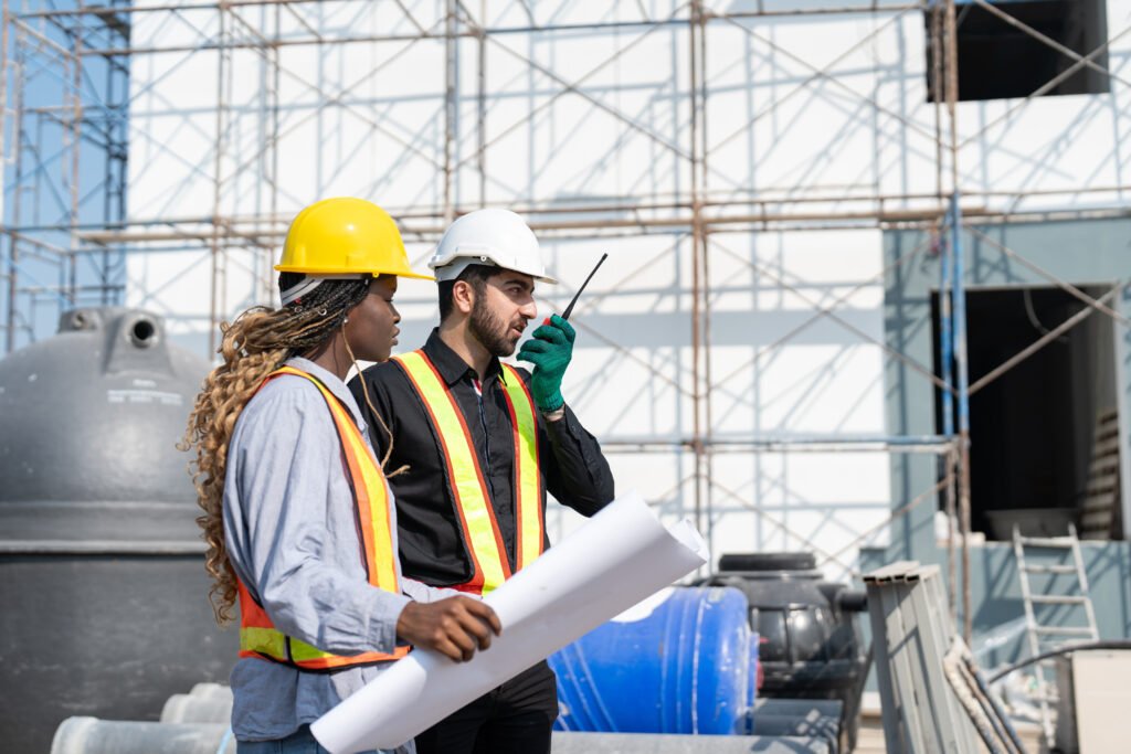 CAO civil engineer and African architect woman with blueprint discussing structure building project on a construction site